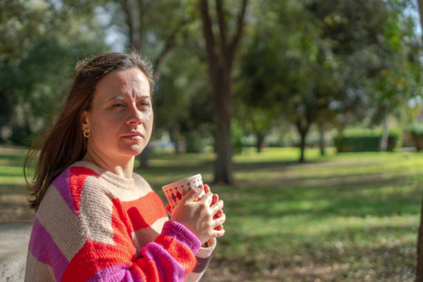 istock young woman drinking a hot drink in nature 1450376939