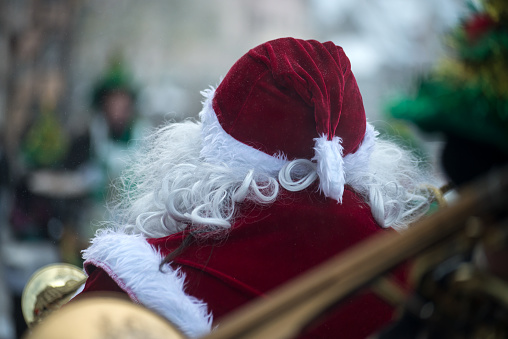 Portrait on back view of man wearing a santa claus costume in the street