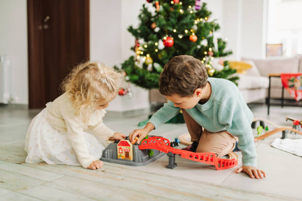 istock Two children playng in front of the Christmas tree 1450380687