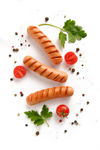 grilled sausages with herbs and tomato isolated on white background