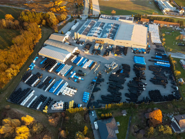 istock Factory building producing plastic pipes with large array of solar panels on the roof at sunset aerial 1450384813