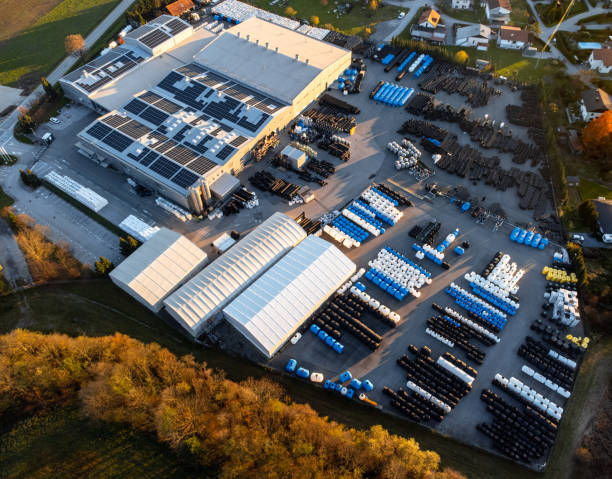 istock Factory building producing plastic pipes with large array of solar panels on the roof at sunset aerial 1450384909