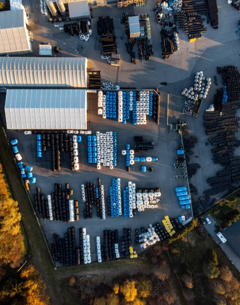 istock Factory building producing plastic pipes with large array of solar panels on the roof at sunset top down 1450384910