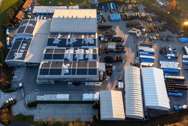 istock Factory building producing plastic pipes with large array of solar panels on the roof at sunset aerial 1450384911