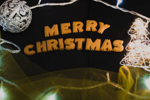 istock Gingerbread words Merry Christmas on old black table with Christmas decorations 1450393092