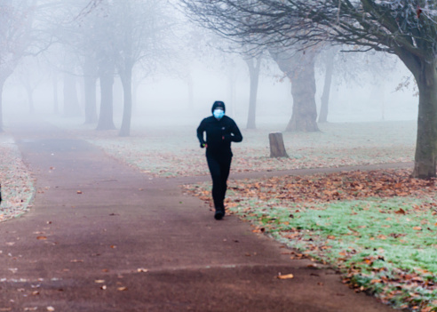 London, United Kingdom, 11 December 2022:  Thick fog in the early morning  jogger run in London ParkLondon, United Kingdom, 11 December 2022:  Thick fog in the early morning as people walking, jogger run in London Park