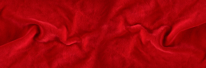 Red velvet texture for postcard or background for design. Red background for Christmas theme or Valentine's day, high quality, large format. Abstract texture of draped red velvet.