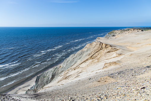The iconic coast line in Denmark with rocks, sand dunes and the ocean
