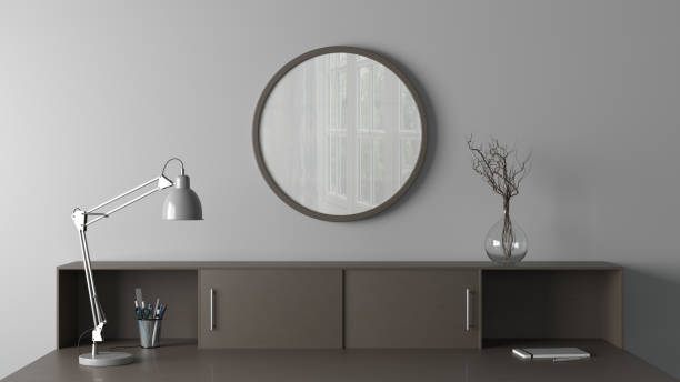 istock Dark wooden round poster frame mock up on the white wall of home studio workspace. Front view. 1450397224