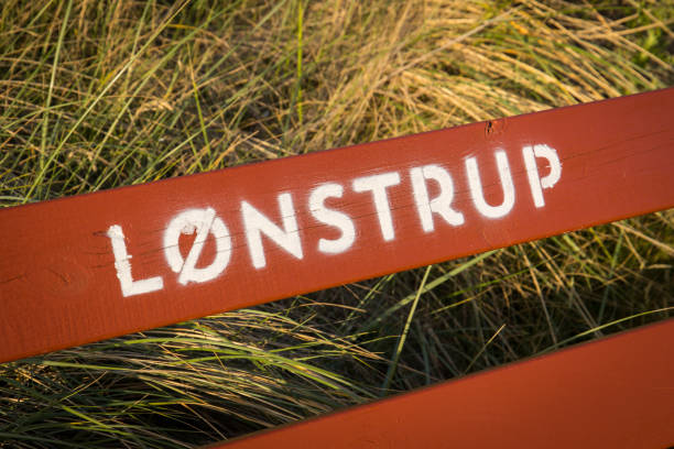 Letters of the danish village Lønstrup on a red bench with some grass in the bakground Letters of the danish village Lønstrup on a red bench with some grass in the bakground hjorring stock pictures, royalty-free photos & images