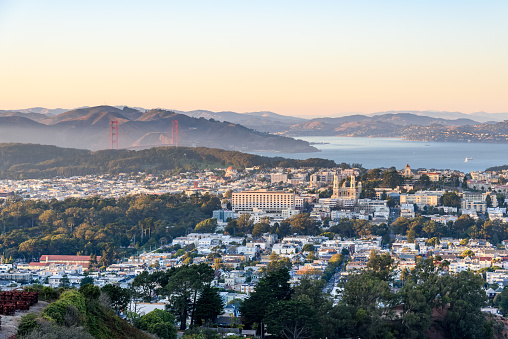 Elevated view of a residential district of San Francisco as seen from Twin Peaks at sunset in autumn. The Golden Gate Bridge and the bay are in background. California, USA.