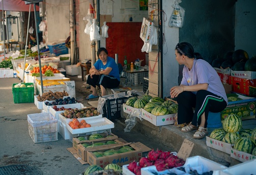Wuhan, China – July 10, 2022: two fruit shop owners chatting