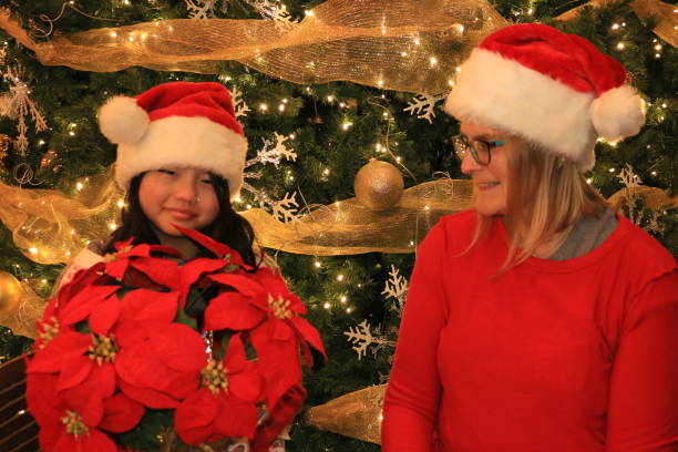 istock Daughter Giving Mom a Poinsettia 1450401166