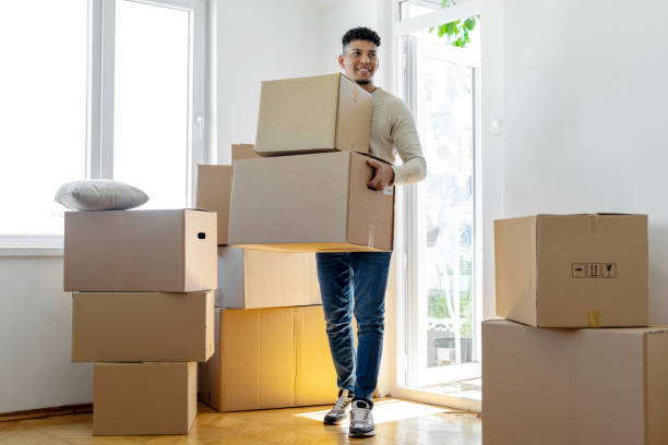 Man carrying boxes into his new home stock photo