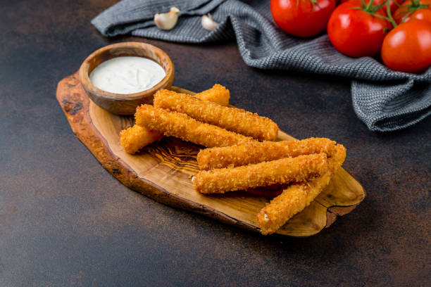 istock fried Cheese sticks with sauce on the board on dark brown table 1450407201