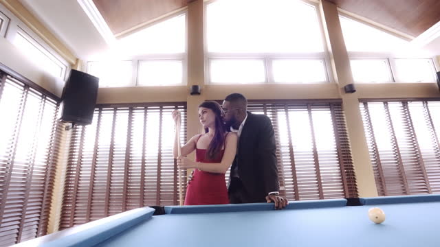 Receding Shot Of A Man Whispering To Woman Near Pool Table