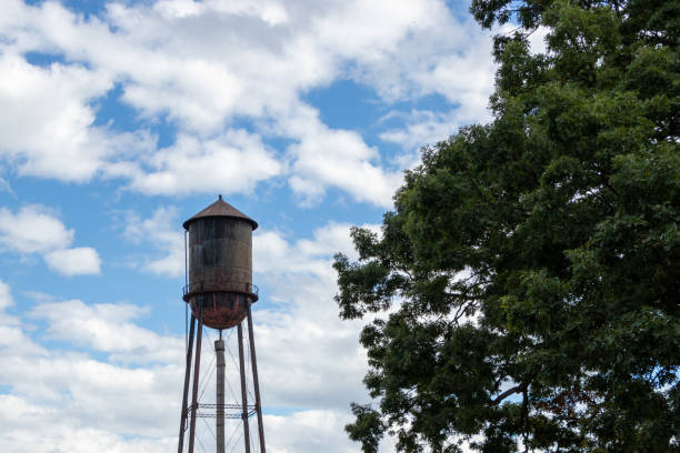 istock water tower with blue sky, clouds and trees in the background 1450409439