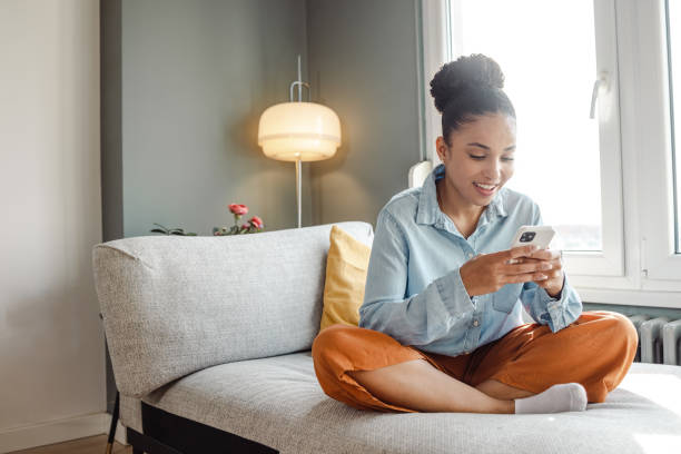 istock A young beautiful woman using a smart phone at home 1450419100