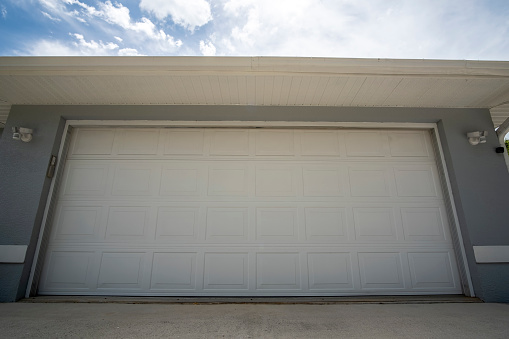 Wide garage double door and concrete driveway of new modern american house.