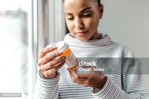 istock A serious young woman holding a bottle of medicines 1450420379