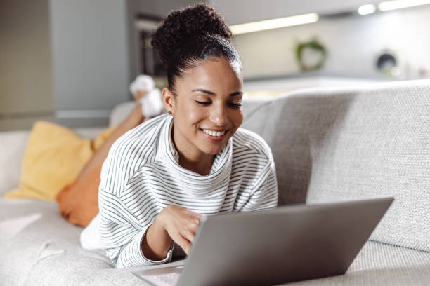 istock Young woman relaxing at home and using technology 1450420887