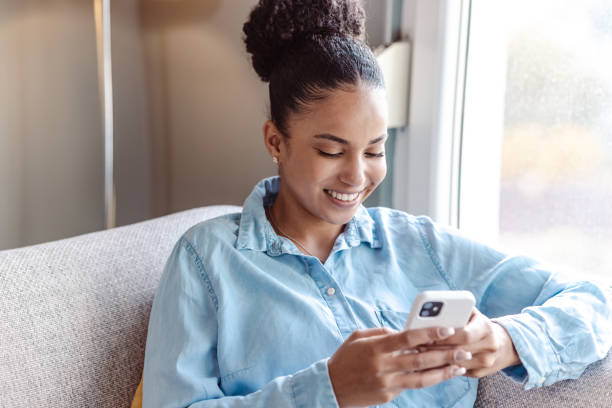 istock A young beautiful woman using a smart phone at home 1450420914