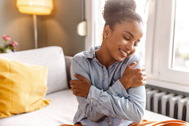 istock Smiling beautiful woman hugging self 1450421945