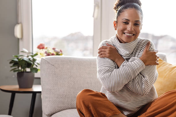 istock Smiling beautiful woman hugging self 1450422187