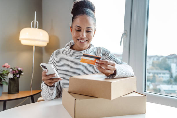 istock Young beautiful woman performing e-commerce activities on smart phone 1450422473
