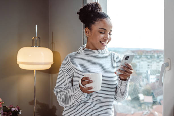 istock A young beautiful woman using a smart phone at home 1450423120