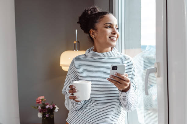 istock A young beautiful woman using a smart phone at home 1450423122