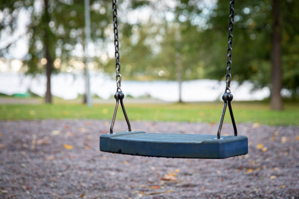 istock Close up of empty swing set in public park 1450426595