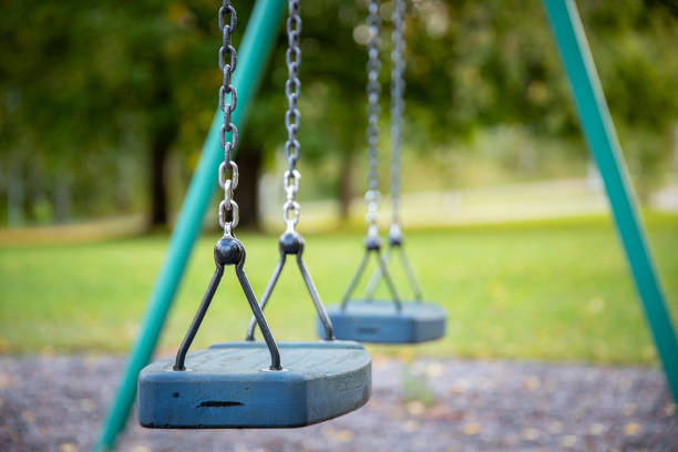 istock Close up of empty swing set in public park 1450426610