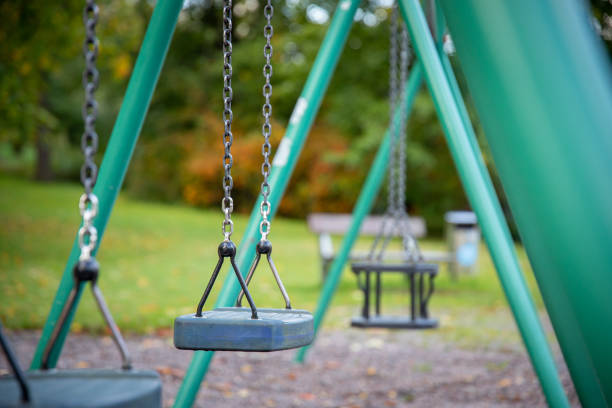istock Close up of empty swing set in public park 1450426625
