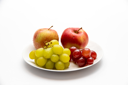 A Close up of apples and grapes on a plate