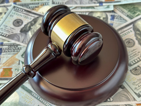 Judge gavel and dollar roll on money background