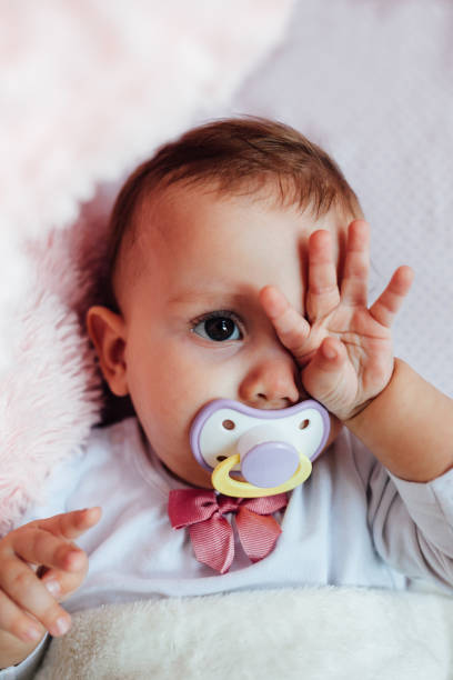 istock Sleepy baby rubs eyes 1450435037