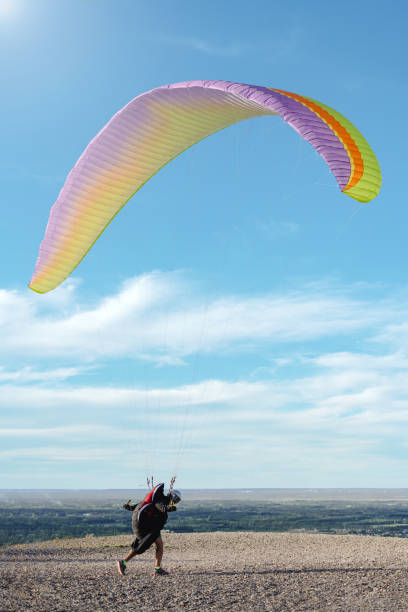 Man running to the risk ready for paragliding flight. Vertical photography