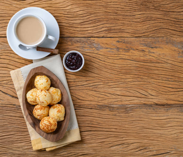 istock Typical brazilian cheese bun in a plate over wooden table with coffee latte, jam and copy space 1450436699