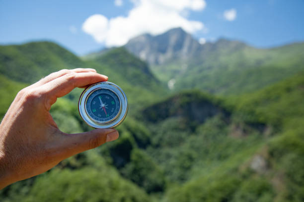 istock Holds a compass against the backdrop of a mountain 1450439063