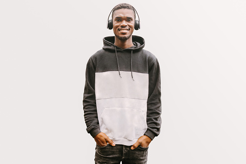 Relaxed confident African man in wireless headphones enjoying songs. Isolated portrait