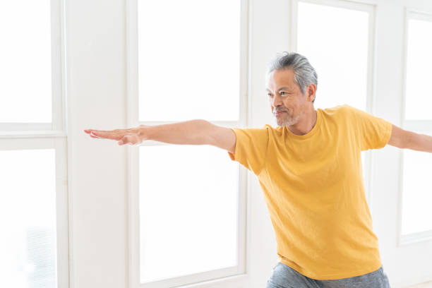 istock elderly man exercising in the room 1450444678