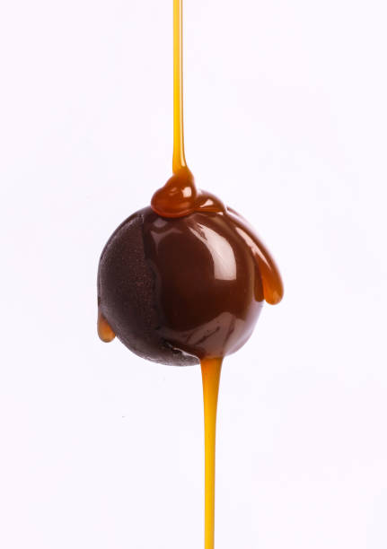 istock Chocolate dripping from top on choco ball on white background. 1450444920