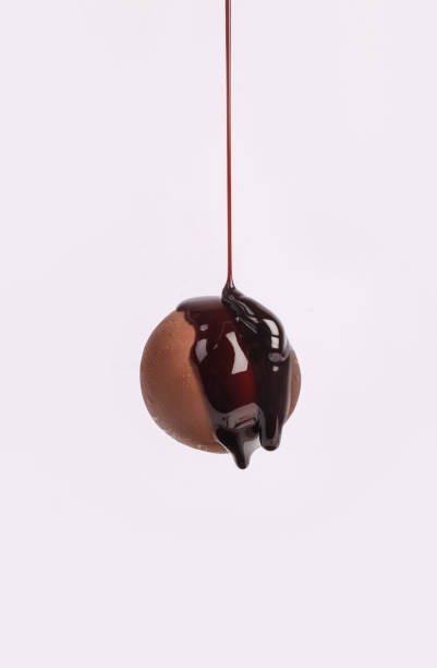 istock Chocolate dripping from top on choco ball on white background. 1450444922