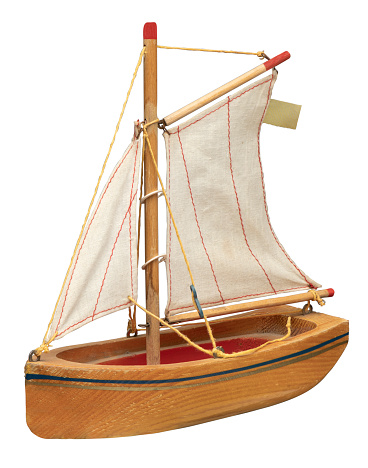A 3/4 view of a vintage wooden toy sailboat on white background with clipping path
