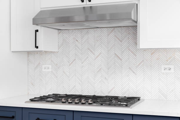istock A kitchen stove top detail with blue and white cabinets and a herringbone tiled backsplash. 1450444940