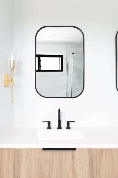 istock A bathroom with a wood cabinet and gold sconces. 1450445891