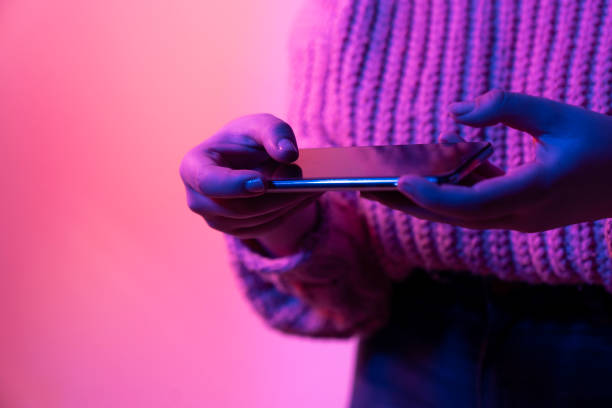 istock Tablet in female hands on a neon background 1450446171