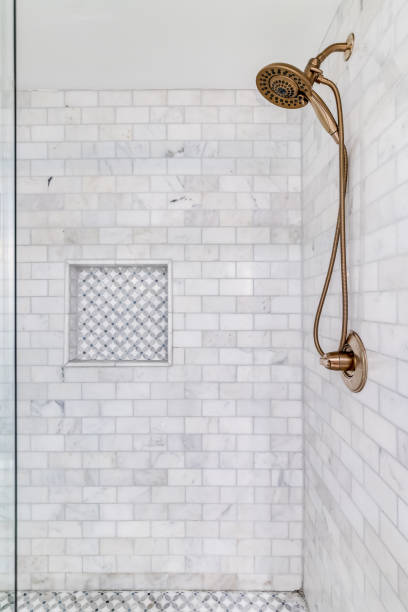 istock A shower with marble tiles and a gold shower head. 1450448828