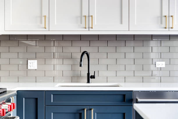 a kitchen sink detail shot with white and blue cabinets. - domestic kitchen contemporary domestic room lifestyles imagens e fotografias de stock